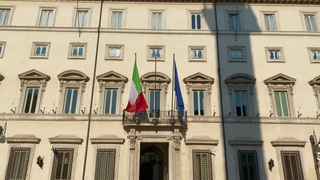 the flags of Italy and Europe displayed on the main balcony of Palazzo Chigi, the seat of the Italian government in Rome on a sunny winter day.