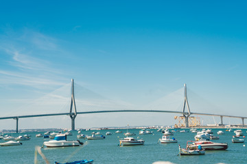 View of the bridge over the water on which a huge number of boats floats