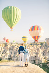 Wedding travel. Honeymoon trip. Couple in love among balloons. Couple in love in Cappadocia. Couple in Turkey. Man and woman traveling. Flying on balloons
