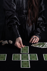 Female tells the future with playing cards. Tarot card concept on the table. Prediction of the...