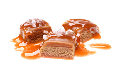 Delicious salted caramel with sauce on white background