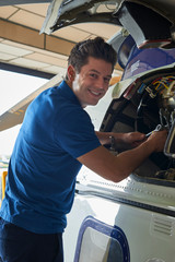 Portrait Of Male Aero Engineer Working On Helicopter In Hangar