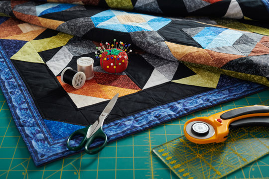  Small quilt, cutting mat and sewing and quilting accessories
