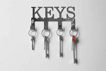 Metal key holder on light wall indoors