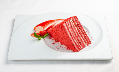 Honey cake with strawberries on a white plate
