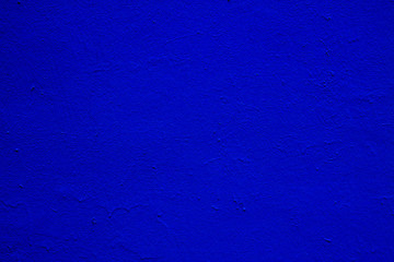 Old textured blue paint on a concrete wall.