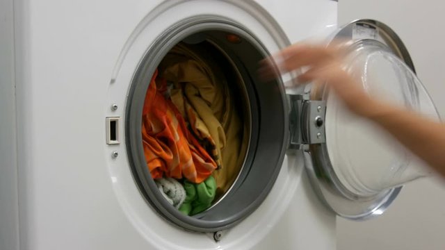 Male Hands Load A Wash Of Colored Laundry Into A Washing Machine And Place A Capsule With Washing Powder. Expedited Shooting.