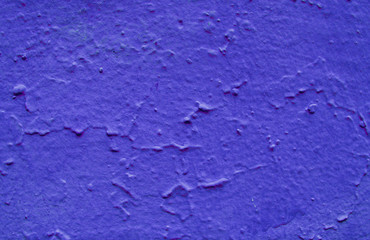 Uneven structure of blue paint on stucco.
