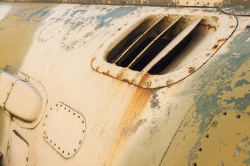 Detail of an old camouflage surface with exfoliated paint on a military aircraft. Fragment of a fuselage of an old jet fighter
