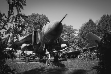 Old Soviet fighter jet among plants. Black and white