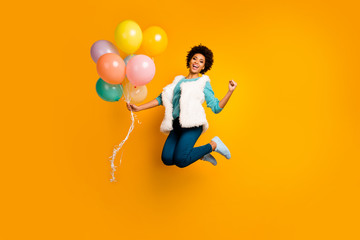 Fototapeta na wymiar Full length photo funky crazy afro american girl jump hold balons win event scream yes raise fists wear white teal stylish trendy sweater blue pants trousers isolated bright color background