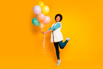 Full size photo cheerful afro american girl enjoy birthday valentine day party hold air baloons wear white turquoise pullover stylish trendy blue pants trousers isolated shine color background