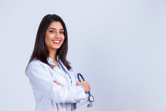 Medical concept of Asian beautiful female doctor in white coat with stethoscope, waist up. Medical student. Woman hospital worker looking at camera and smiling, studio, gray background