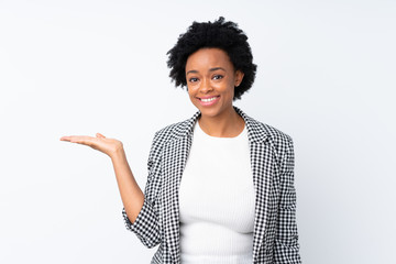 African american woman with blazer over isolated white background holding copyspace imaginary on the palm to insert an ad