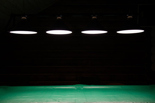 Pool table lit by lamps on a dark background. Low key shooting in low light