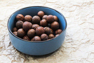 Organic macadamia nuts in blue ceramic bowl