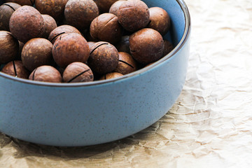 Macadamia nuts in blue ceramic bowl. Vegeterian food concept 