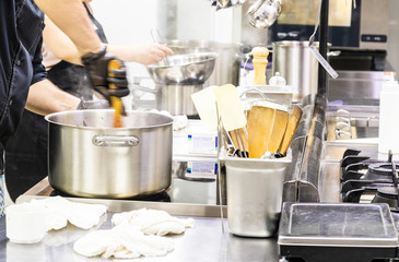 Chef in the kitchen at the restaurant prepares dishes