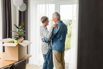 selective focus of mature man and woman dancing in new house