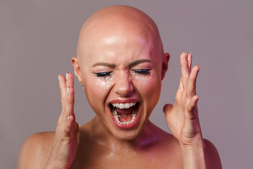 Portrait of caucasian young half-naked bald woman screaming at camera