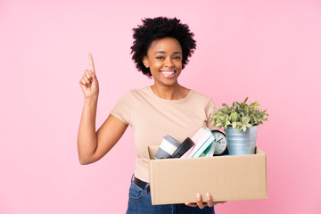 African american woman making a move while picking up a box full of things pointing up a great idea