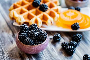 Petit déjeuner sain avec lait gaufre mûres du jardin et fruits confits	