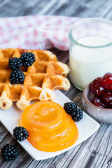 Petit déjeuner sain avec lait gaufre mûres du jardin et fruits confits	