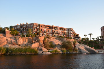 River Nile/ beautiful view for Aswan Egypt and Nubian Egyptian culture. sailing boat sailing in the River Nile and harbor with birds and local houses on the 2 sides 