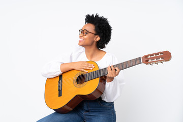 Obraz premium African american woman with guitar over isolated background looking side