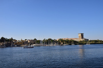 Obraz premium River Nile/ beautiful view for Aswan Egypt and Nubian Egyptian culture. sailing boat sailing in the River Nile and harbor with birds and local houses on the 2 sides 