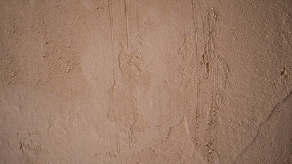 Uneven rough texture of brown stucco.