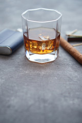 Glass of whiskey with ice, big cuban cigar, matches and hip flask