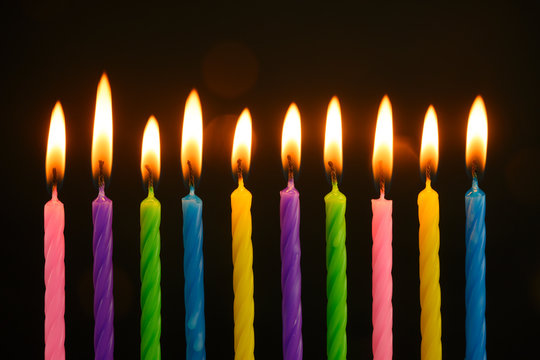 multi-colored candles burn on a birthday cake