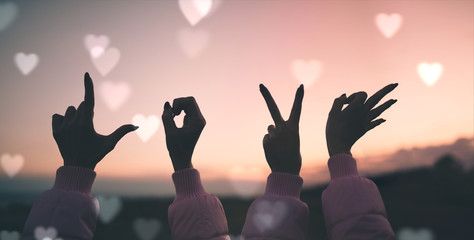 San Valentino, scritta love con le mani con sfondo del cielo al tramonto. Panoramica.