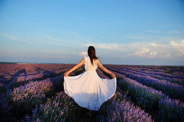 back view of a woman in white dress in lavander field