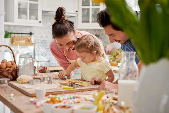 Parents with child decorating cookies for Easter