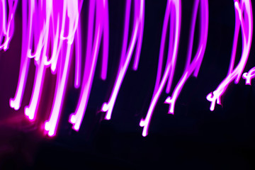 Abstract image of neon pink or lilac lights on a dark background.