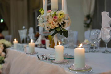 wedding decoration on the wedding table. newlyweds decorated table in a restaurant. beautiful wedding setting with candles, flowers and wedding accessories.