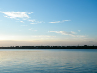 Sunset Skylight Reflection on Lake Water by sun reflector. The moody blues red and yellow in Landscape horizon Background. Dusk to Night Time Lapse Atmospheric mood. Tranquil scene, idyllic atmosphere