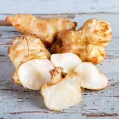 Fresh Jerusalem artichokes on the old wooden table.