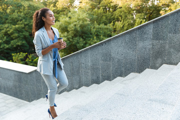 Attractive smiling african business woman walking up