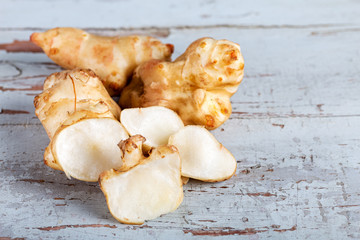 Fresh Jerusalem artichokes on the old wooden table.