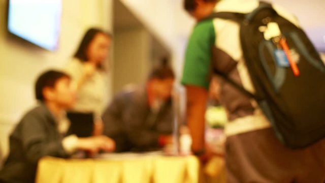 Blurry video of a lot of people are waiting to register in to seminar. Business blurry background. Register activity. Business people are signing up for registration before attending the seminar.