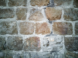 Typical detail of an old wall of an Italian house, made of hand-carved stones eroded by time.