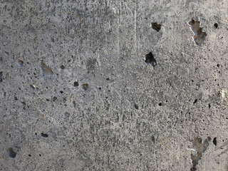 Concrete surface with caverns and exposed gravel stones