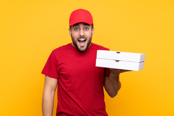 pizza delivery man with work uniform picking up pizza boxes over isolated yellow background with...