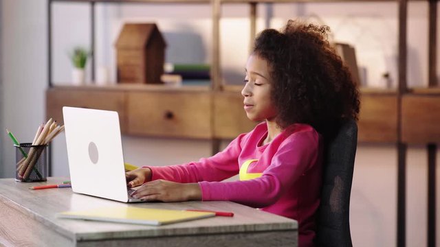 african american child having video chat on laptop