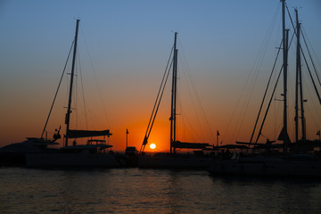 Fototapeta na wymiar Glow of setting sun through rigging of yachts moored