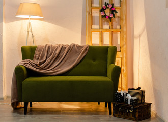 Cozy home interior with bright lamp and green sofa.