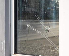 Fototapeta na wymiar Einschusslöcher in einer Fensterscheibe